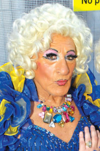 Maisie Trollette Drag Artist in blue and gold gown and blond wig