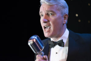 Peter Stanford Swing & Rat Pack Singer Performing Live Against A Black Background