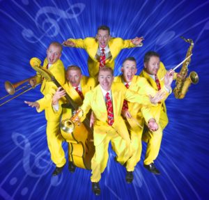 The Jive Aces posing with their instruments wearing their famous canary yellow zoot suits in front of a blue background emblazoned with musical notations