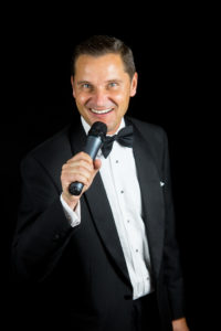 Swing Singer Andy Mack singing at a formal event in black tie