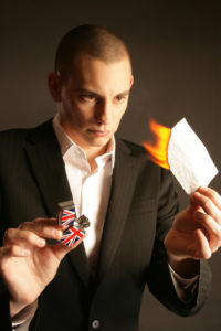 Close up magician Matt burning a piece of paper as part of a magic trick