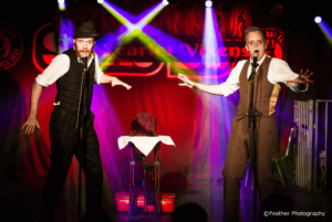 Comedy Magicians Griffin & Jones Performing Live Against A Colourful Stage Background