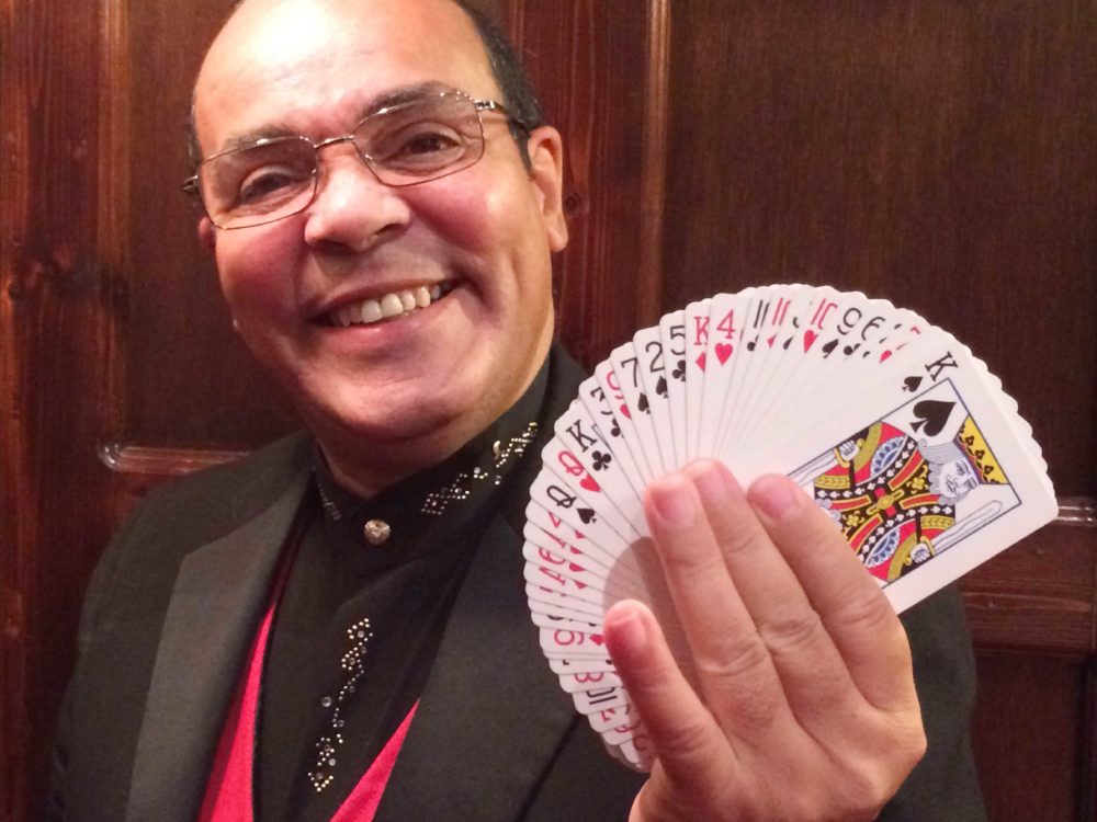 Close Up Magician Jay Smiling and Holding a Fan of Playing Cards