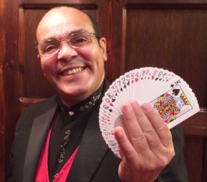 Close Up Magician Jay Smiling and Holding a Fan of Playing Cards