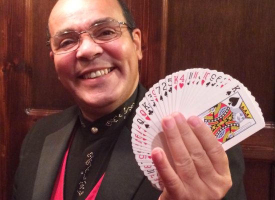 Close Up Magician Jay Smiling and Holding a Fan of Playing Cards