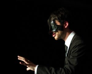 Mind reader and psychic comedian Peter Antoniou mid prediction with his hand outstretched and his eyes covered with black duck tape