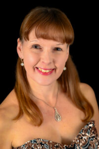 Ruth Faye Cabaret Singer smiling towards the camera wearing a stunning sequinned ball gown