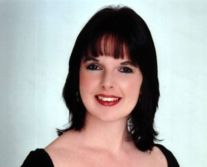 Ruth Cabaret And Swing Singer Smiling Against A Blue White Background