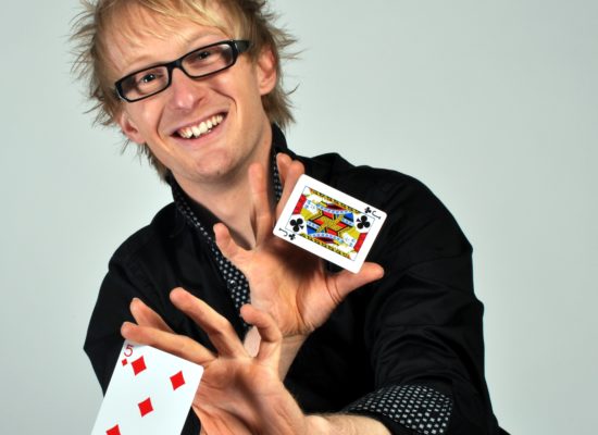 Close Up Magician Sonic Displays The Five Of Diamonds And The Jack Of Clubs Playing Cards In His Hands