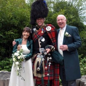 Bagpipe Sergeant John in Full Royal Stewart Tartan Uniform On A Wedding Day Performance