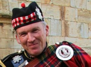 Bagpipe Player John In Full Regalia Against The Stone Wall Of A Wedding Venue