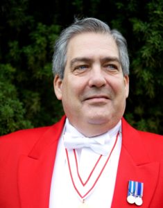 Professional Toastmaster and MC Nigel In Full Red Coat Regalia Displaying Medals Of Office