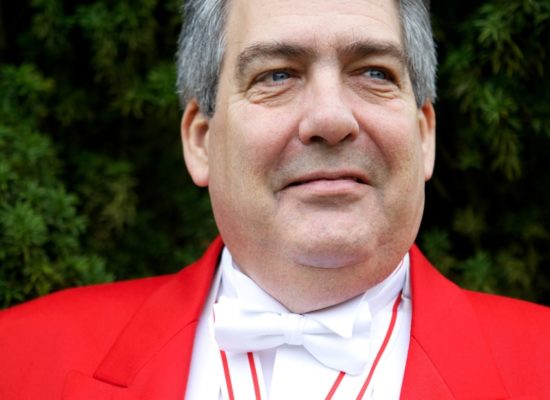 Professional Toastmaster and MC Nigel In Full Red Coat Regalia Displaying Medals Of Office
