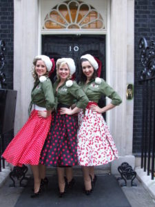 The Spinettes Outside 10 Downing Street in Santa Hats and Vintage Costuming