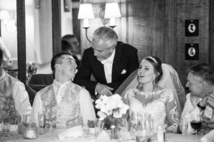 Singing Master Of Ceremonies Chatting With Groom On The Top Table