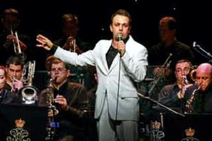 Shane Wearing A White Suit Performing A Live Gig With His Swing Band