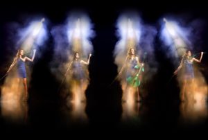 Siren Electric Violin Quartet In Haze Spotlights Against A Black Background