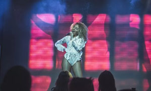 Beyonce Tribute In White Lace Against A Pink Backdrop