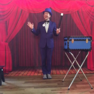 Magical Ritchie Childrens Entertainer In Blue Suit & Bowler Hat Holding An Oversized Magic Wand