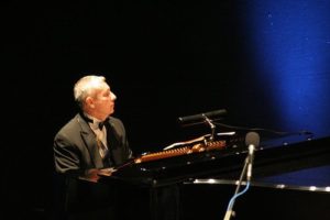 Pianist Ashley Playing A Black Grand Piano