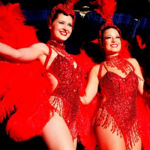 Vegas Showgirls In Red Feathered Costumes Performing On Stage