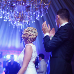 Wedding Couple Beneath a Crystal Chandelier First & foremost Entertainment